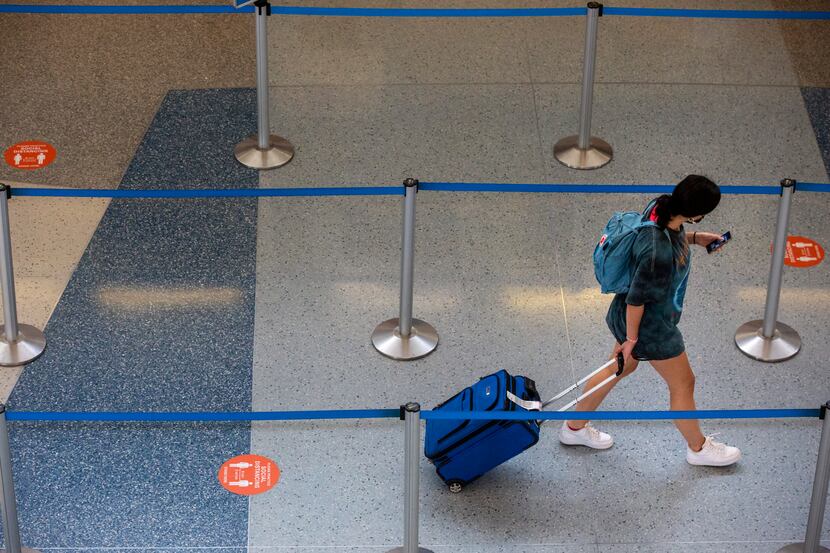 A passenger walks past social distancing markers in Terminal D at DFW International Airport.