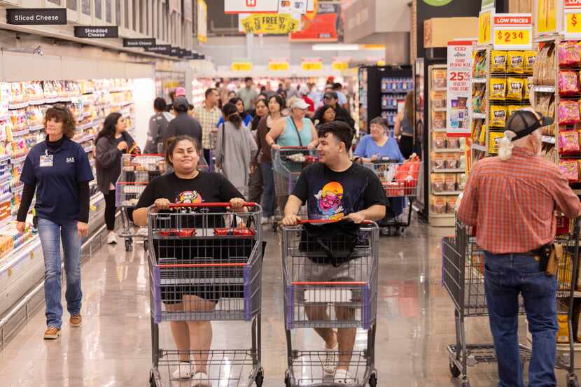 Customers Jennifer Lopez (center left) and Oscar Morales (center right) of Allen shop during...