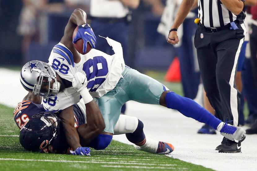 Dallas Cowboys wide receiver Dez Bryant (88) gets pulled down with his foot caught...