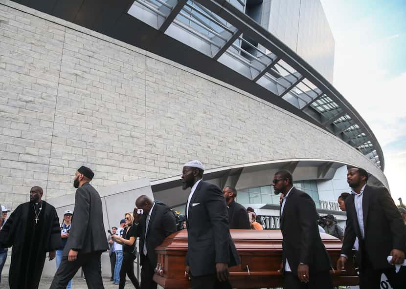 Members of the clergy and community carried empty coffins around AT&T Stadium in Arlington...
