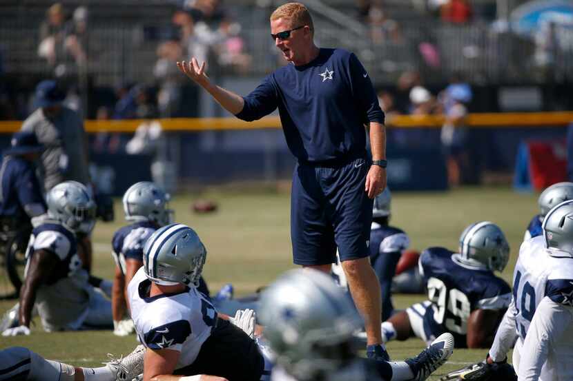 Dallas Cowboys head coach Jason Garrett talks to his players during a warm-up at the...