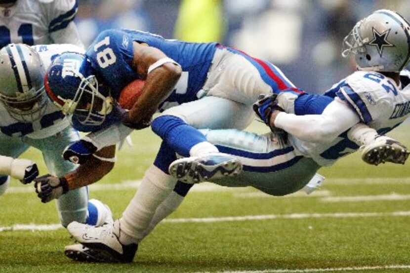  Cowboys Mario Edwards pulls the leg of Giants Amani Toomer as he gets a helping hit from...