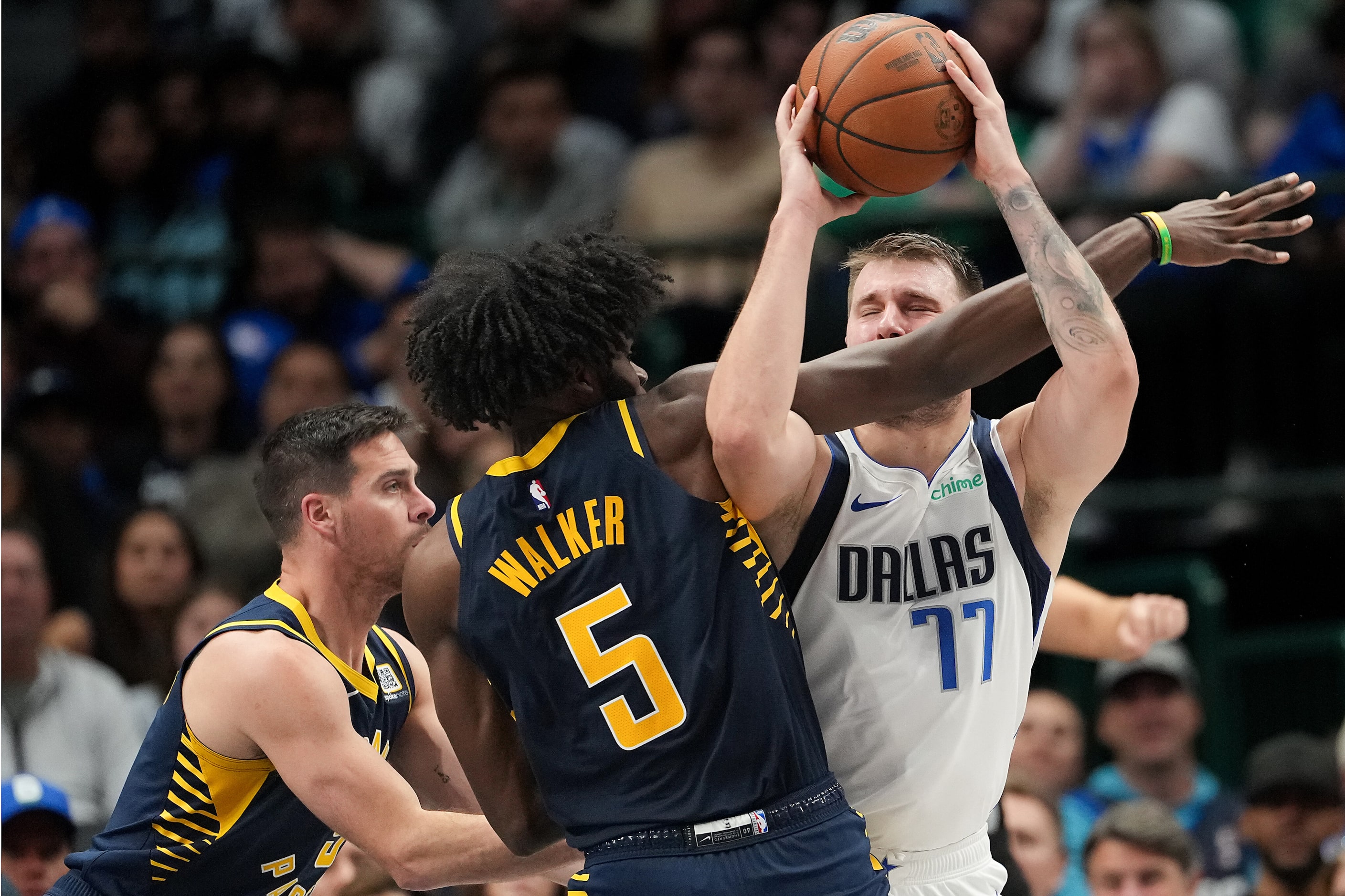 Dallas Mavericks guard Luka Doncic (77) is fouled by Indiana Pacers forward Jarace Walker...