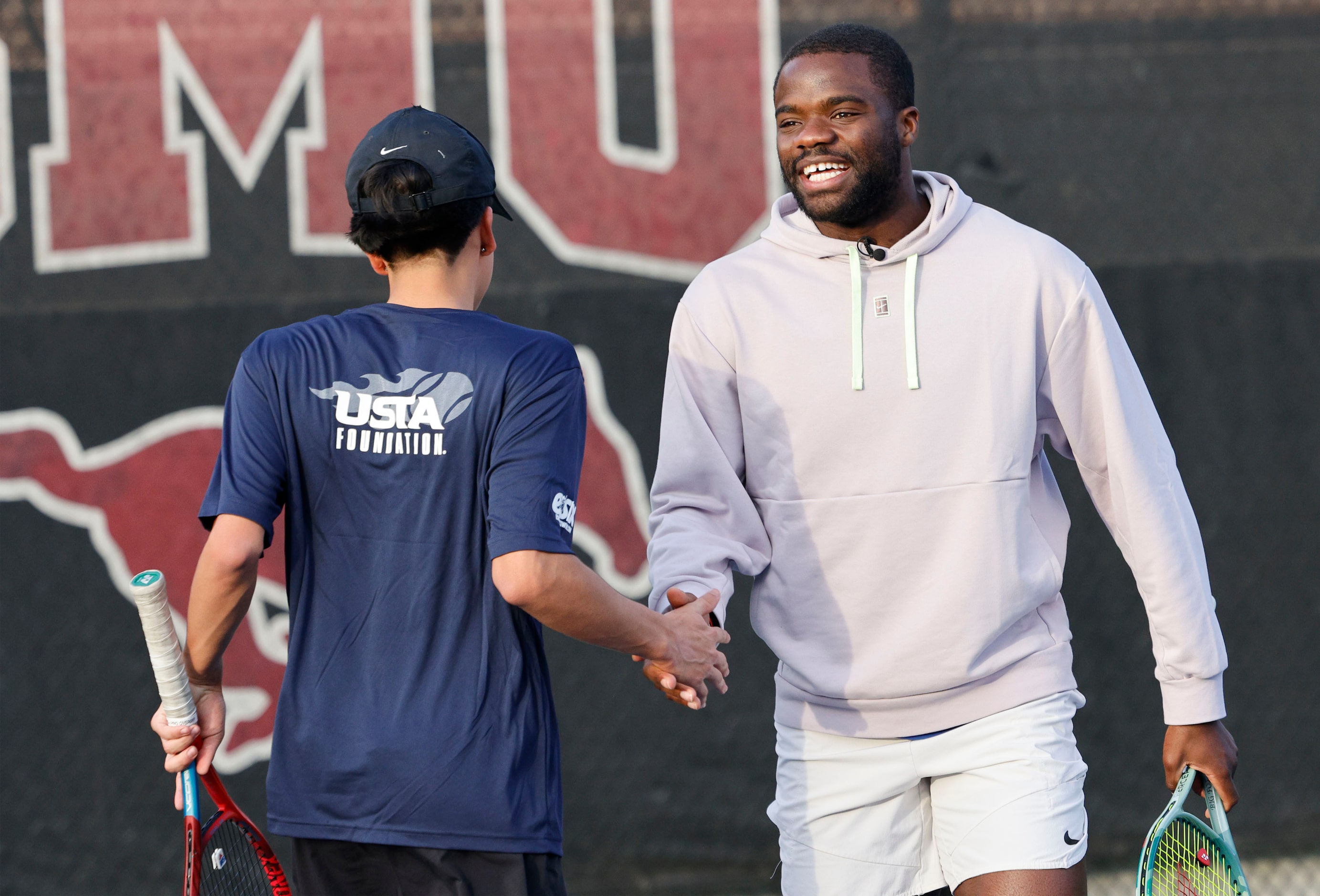 Cruz Beltran, 16, of Dallas Tennis Education Academy gets a high-five from American tennis...