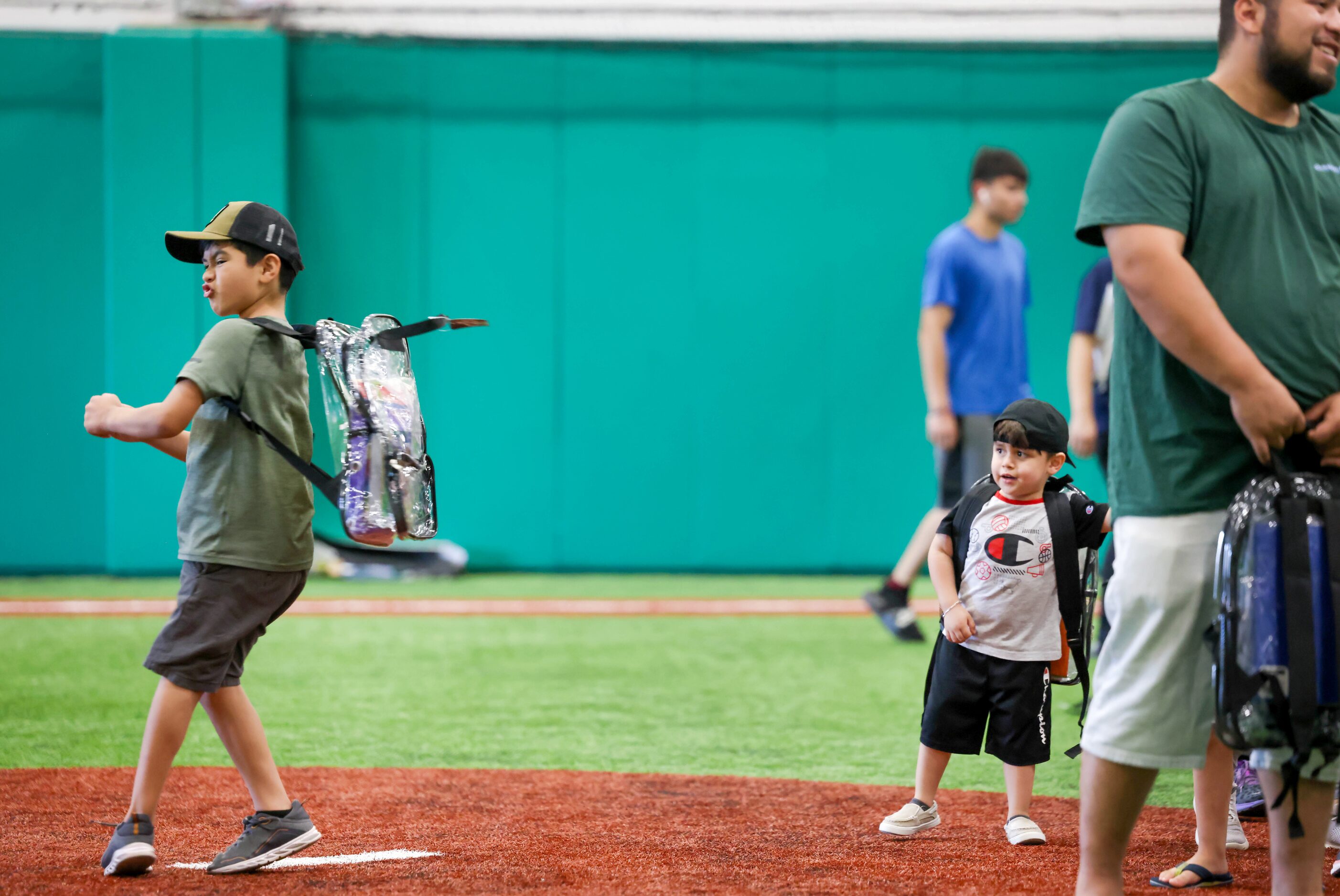 Baltazar Romero (left), 7, spins with a new backpack stuffed with school supplies as Eithan...