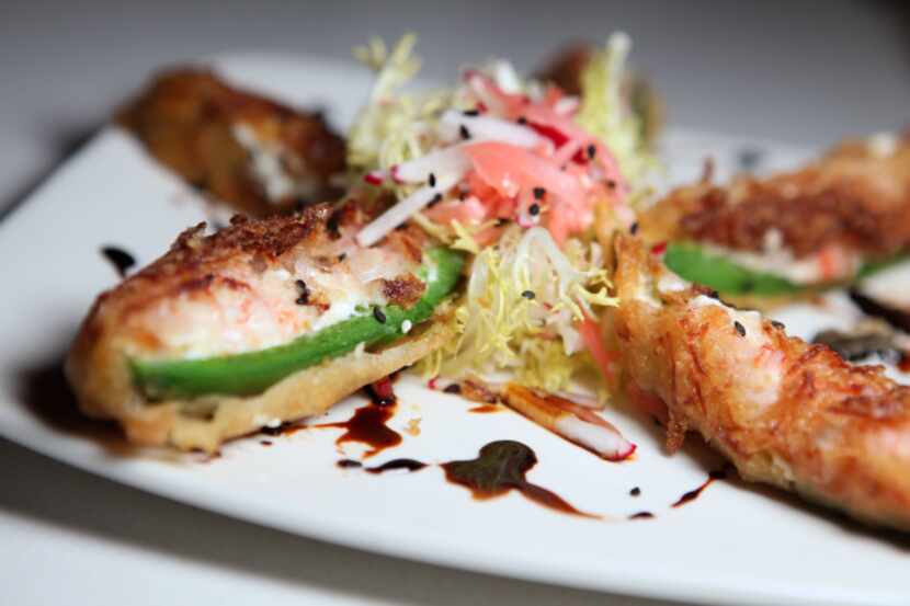 Monica's tempura jalapenos are filled with cream cheese and kani "crab," and drizzled with...
