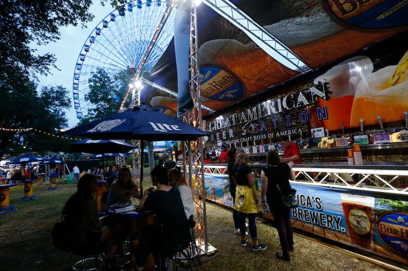 People order beers at the Beer Haven under the Ferris wheel during the State Fair of Texas...