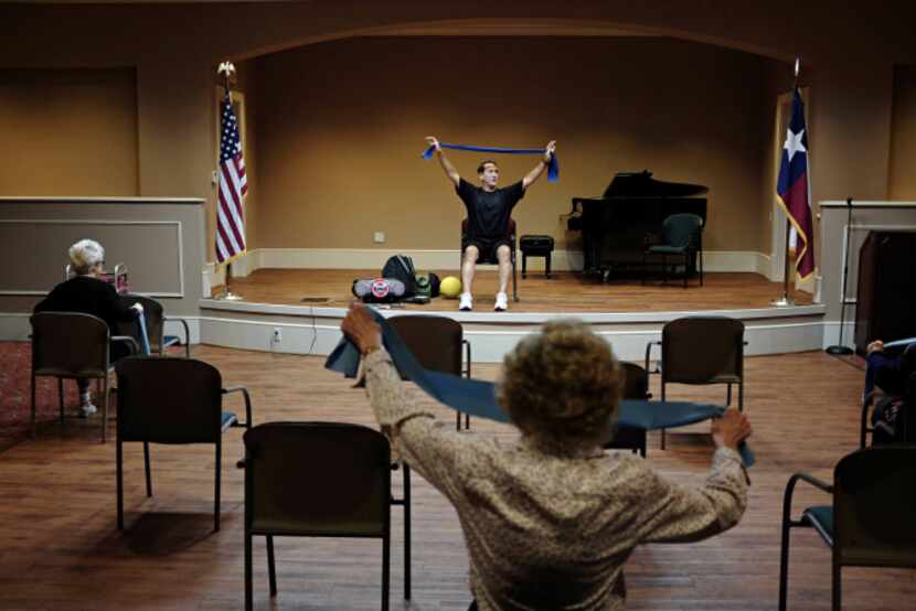 Charles Plafcan, fitness director at Edgemere, leads a seated exercise class Wednesday,...