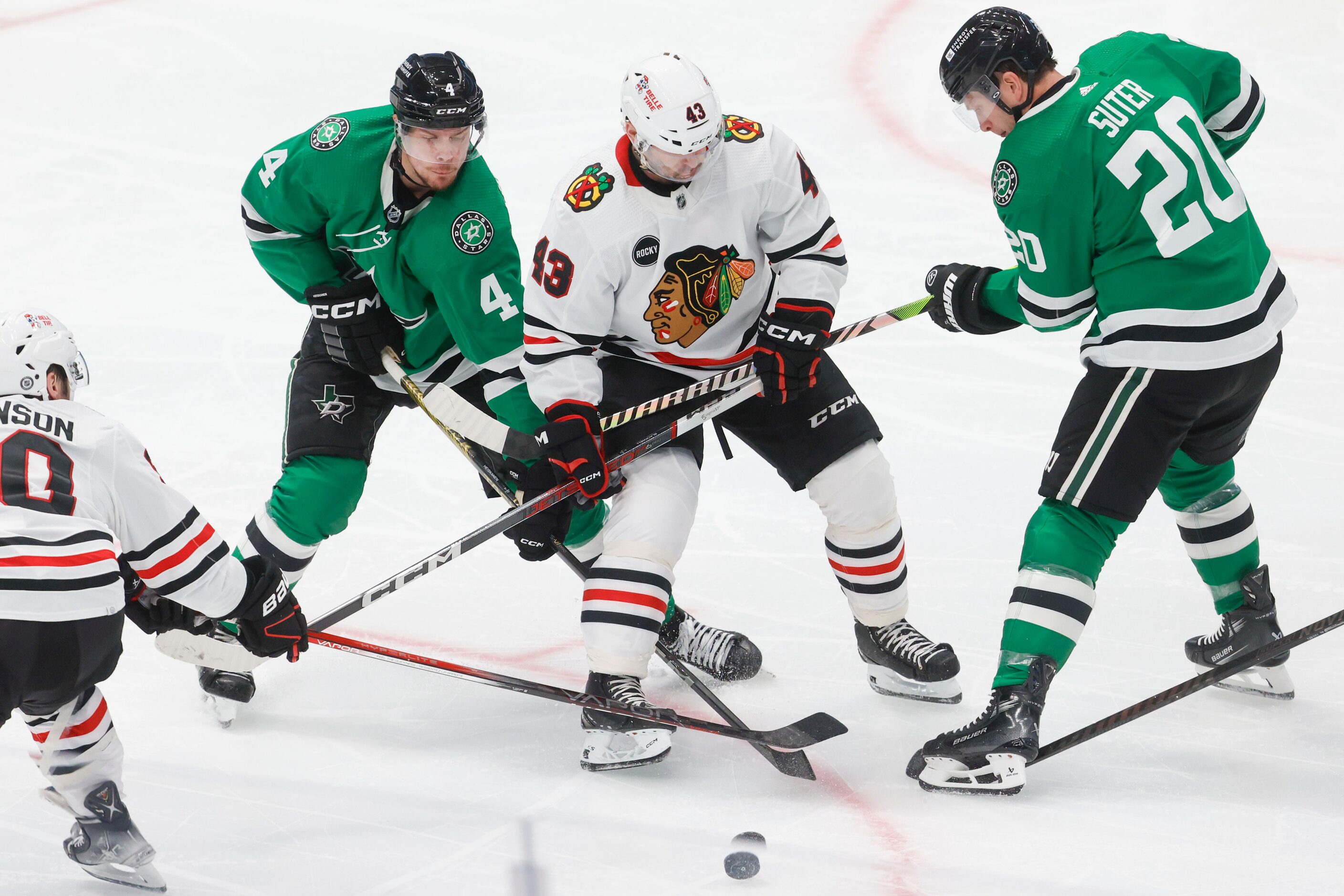 Chicago Blackhawks center Colin Blackwell (center) battles for the puck against Dallas Stars...