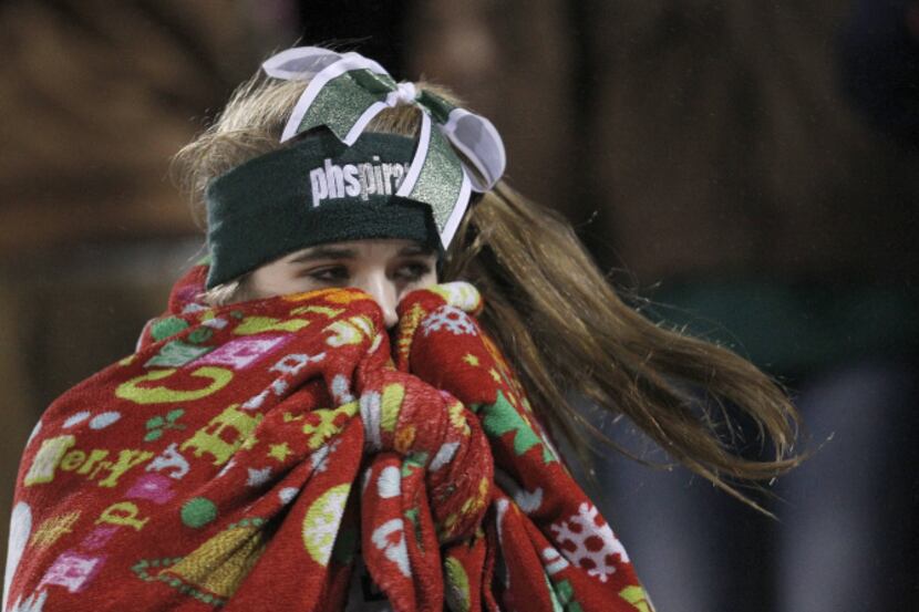 Mesquite Poteet freshman cheerleader Katie Reese bundles up in the first half of the high...