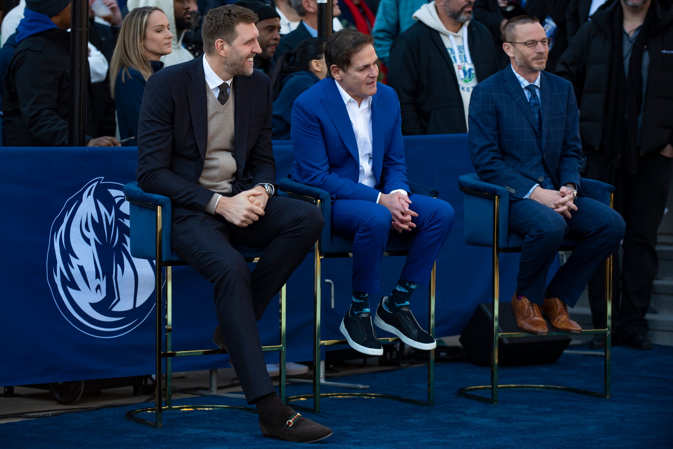 Dirk Nowitzki smiles while sitting next to Dallas Mavericks owner Mark Cuban and Mark...