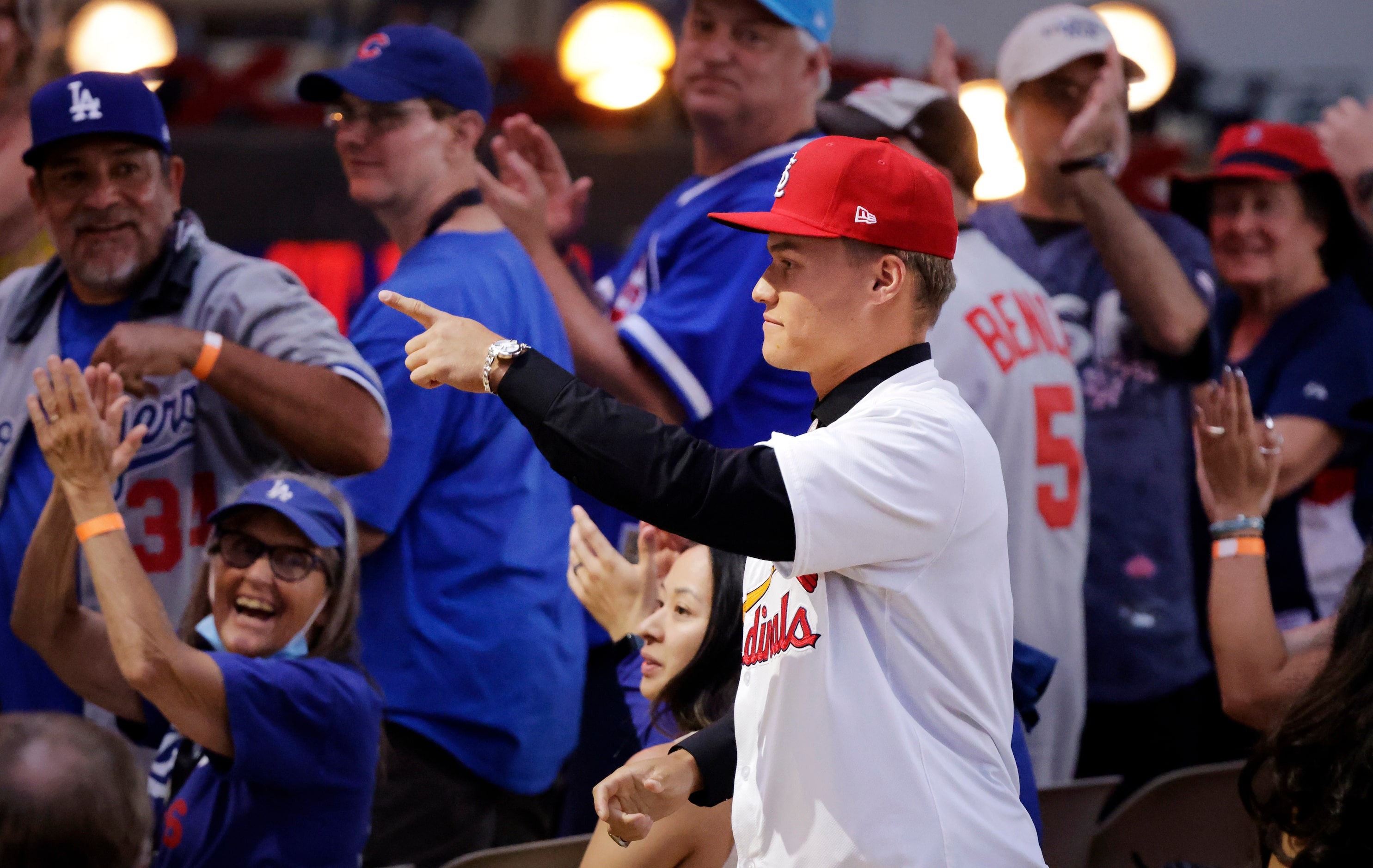 JJ Wetherholt, a shortstop from West Virginia points to fans who cheer his arrival after...