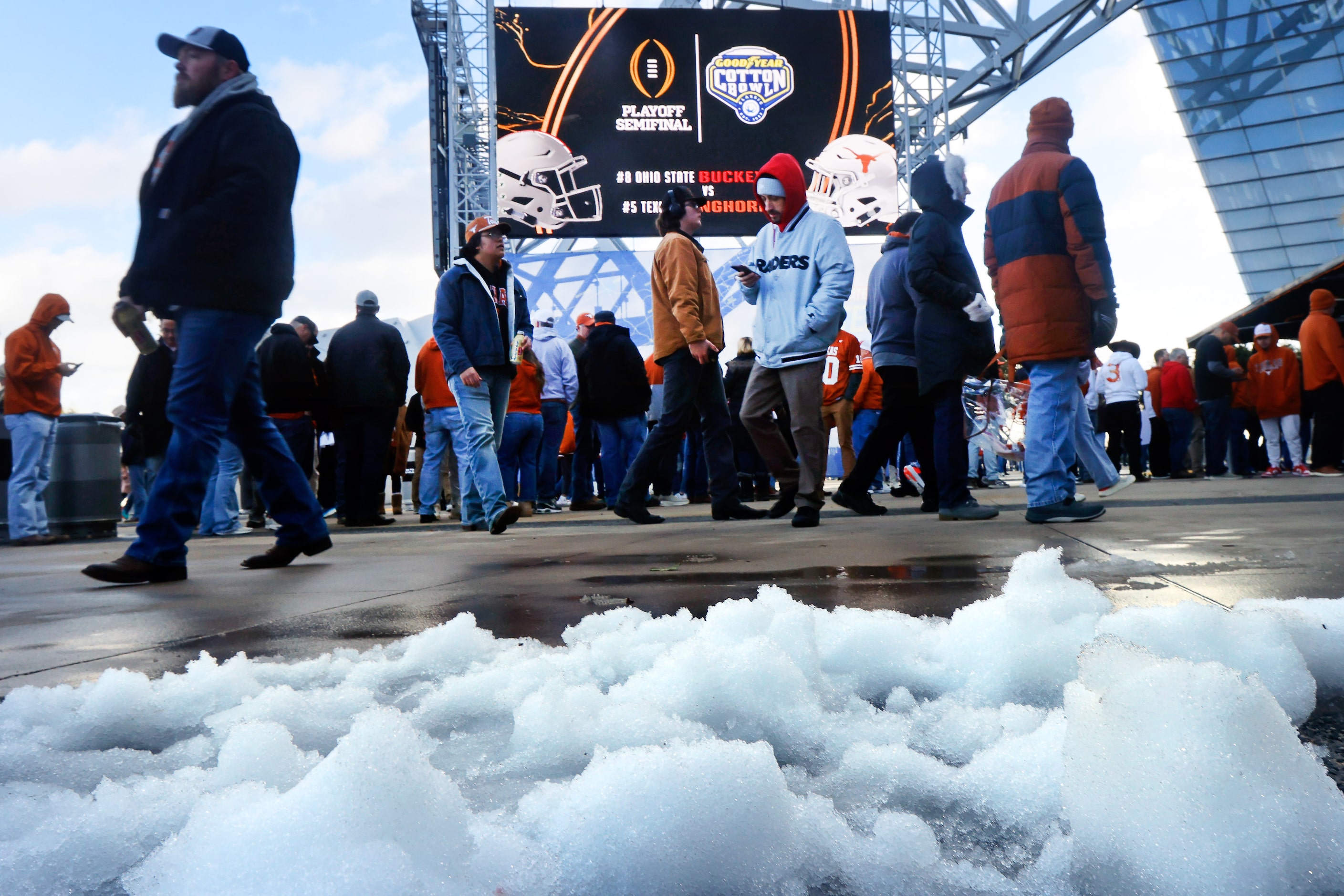 With melting snow on the east plaza, Texas Longhorns and Ohio State Buckeyes fans arrive for...