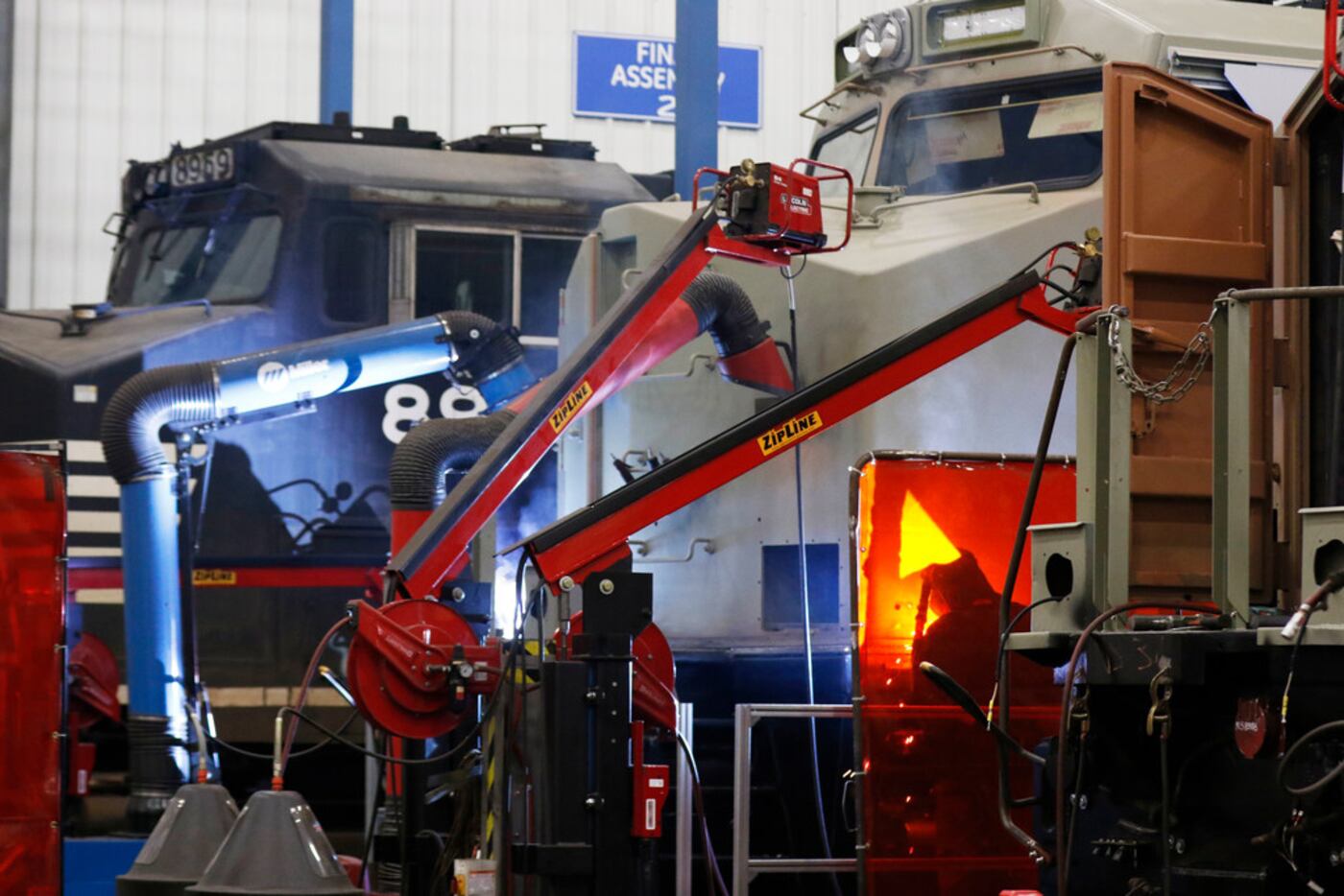 GE workers weld a cab during the refurbishing process of a locomotive at the GE...