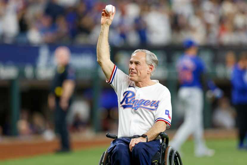 Texas governor Greg Abbott raises the ceremonial first pitch baseball before the Texas...