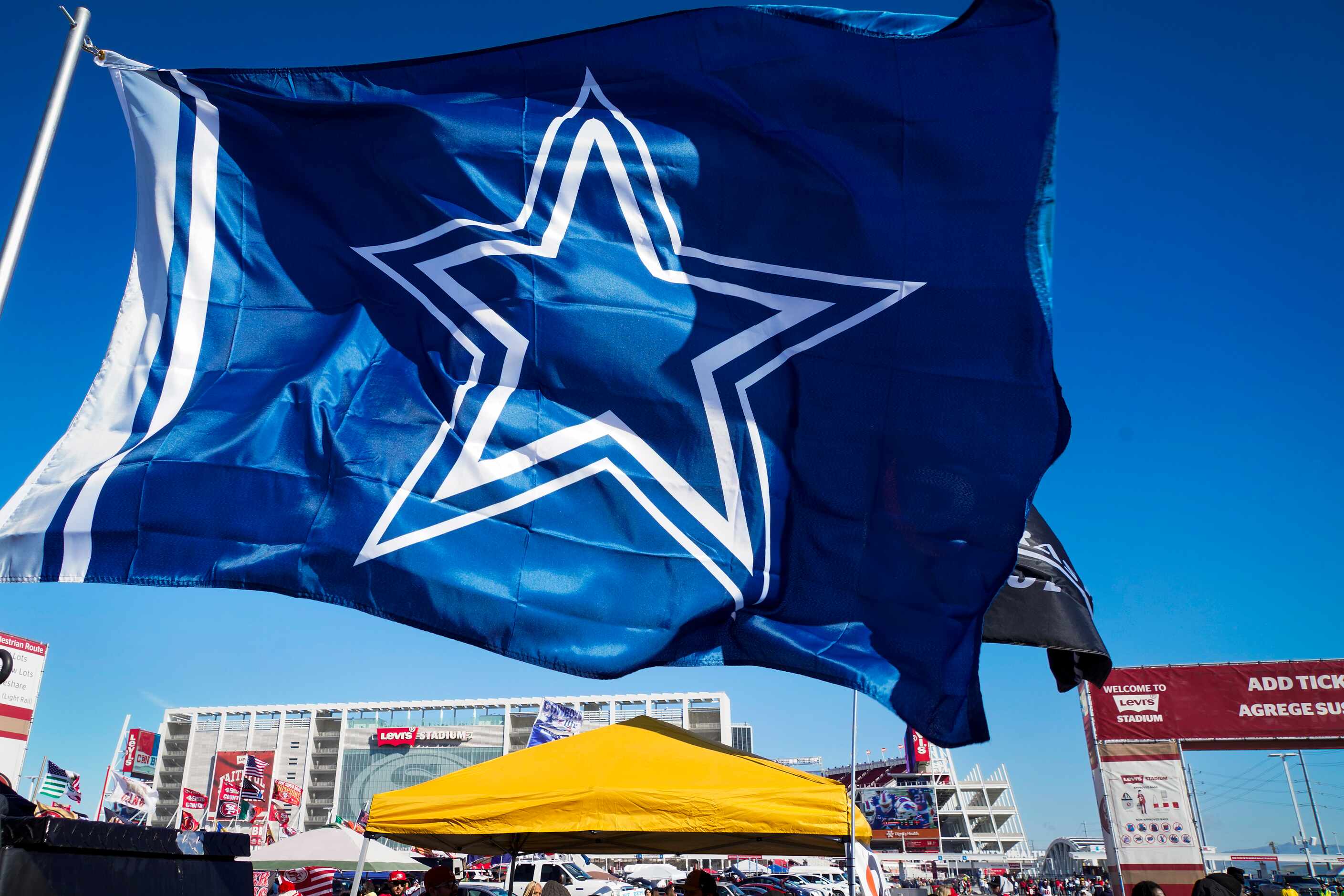 A Dallas Cowboys fan flutters in the breeze as fans tailgate before an NFL divisional round...