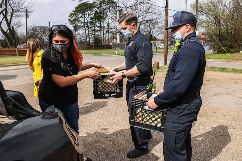 Aidee Lomeli from Fort Worth gets help from firefighters Will Tabor and Richard Courts from...