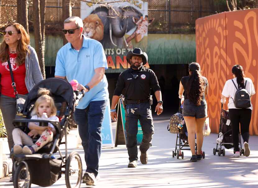 Officer KaShawn McGruder (center) patrols the grounds near the Giants of Savanna exhibit at...