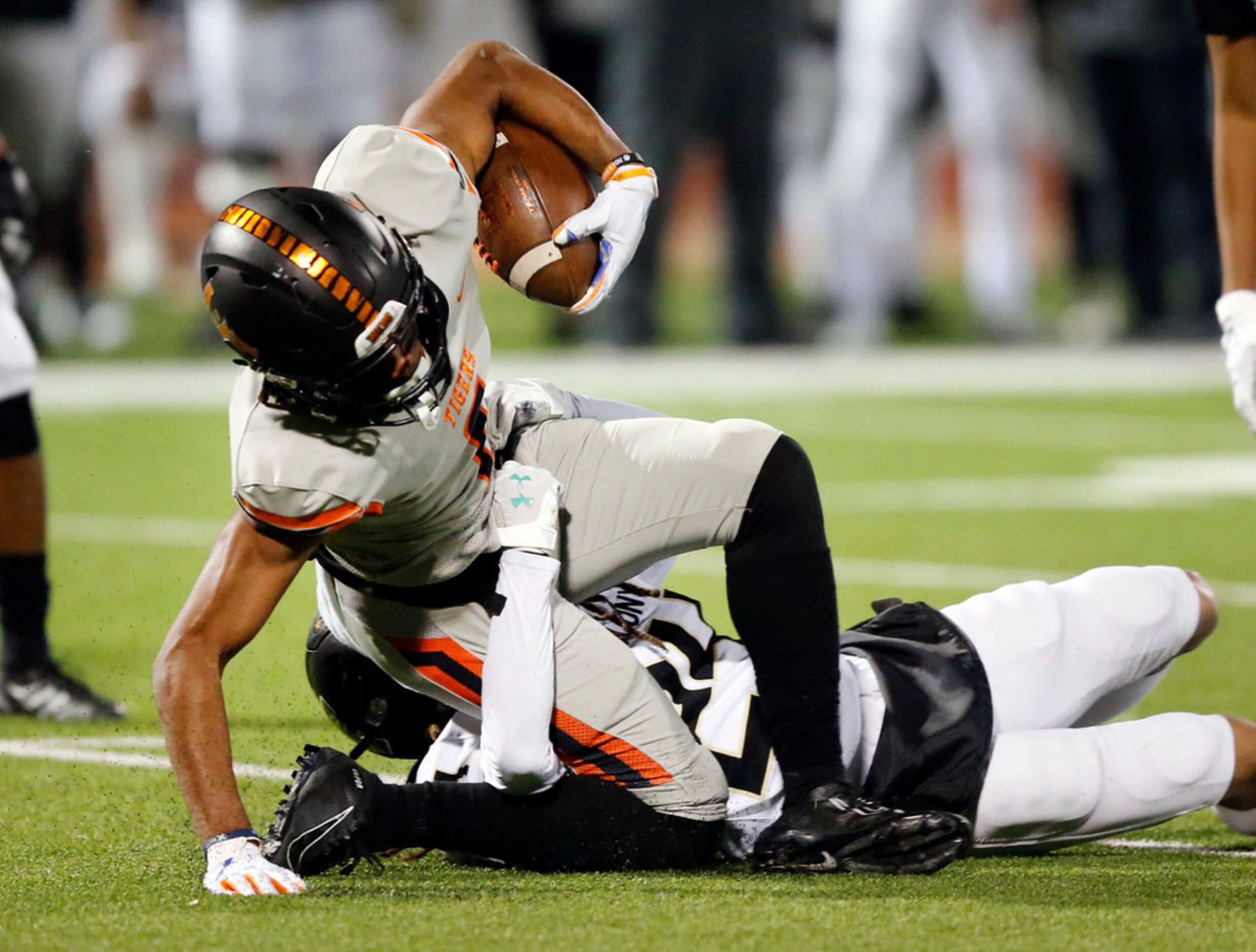 Lancaster wide receiver LaTrell Caples (1) gets his leg under him after as he's tackled by...