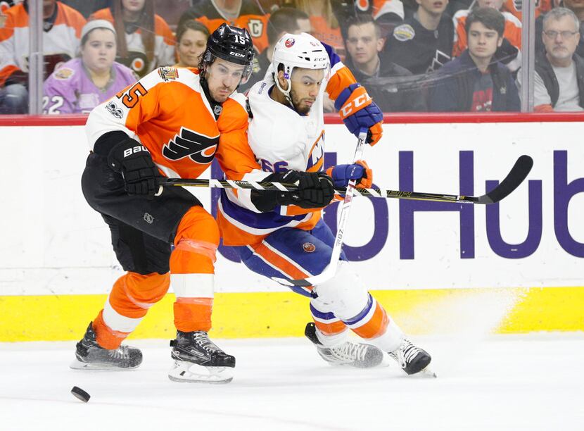 Philadelphia Flyers' Michael Del Zotto, left, tries to keep New York Islanders' Joshua...
