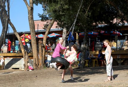 Kids play on a tire swing at the Stix Icehouse in McKinney.