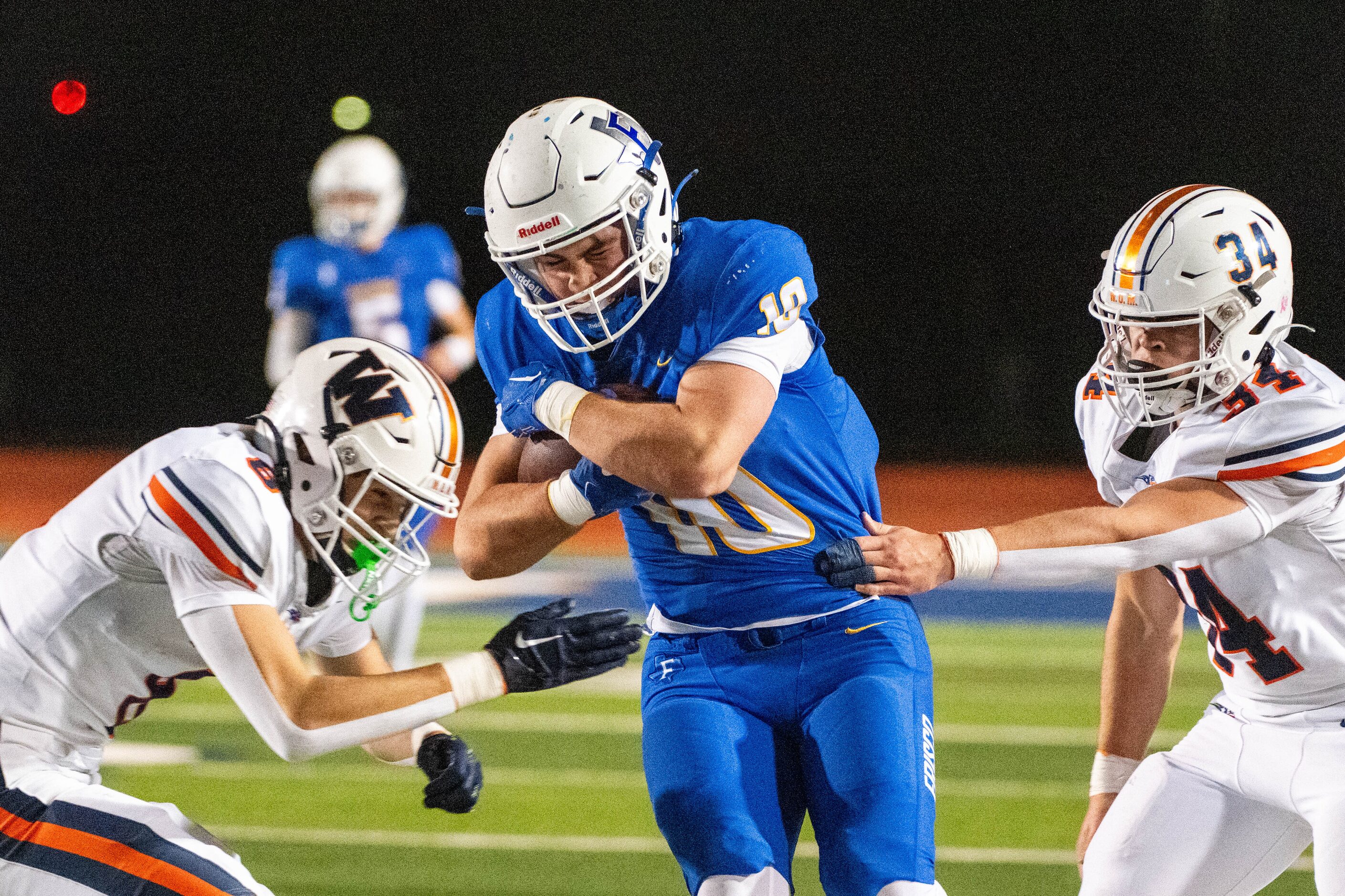 Frisco's Reed Engleman (10) runs between tackles attempts by Wakeland's Ryder Treadway (8)...