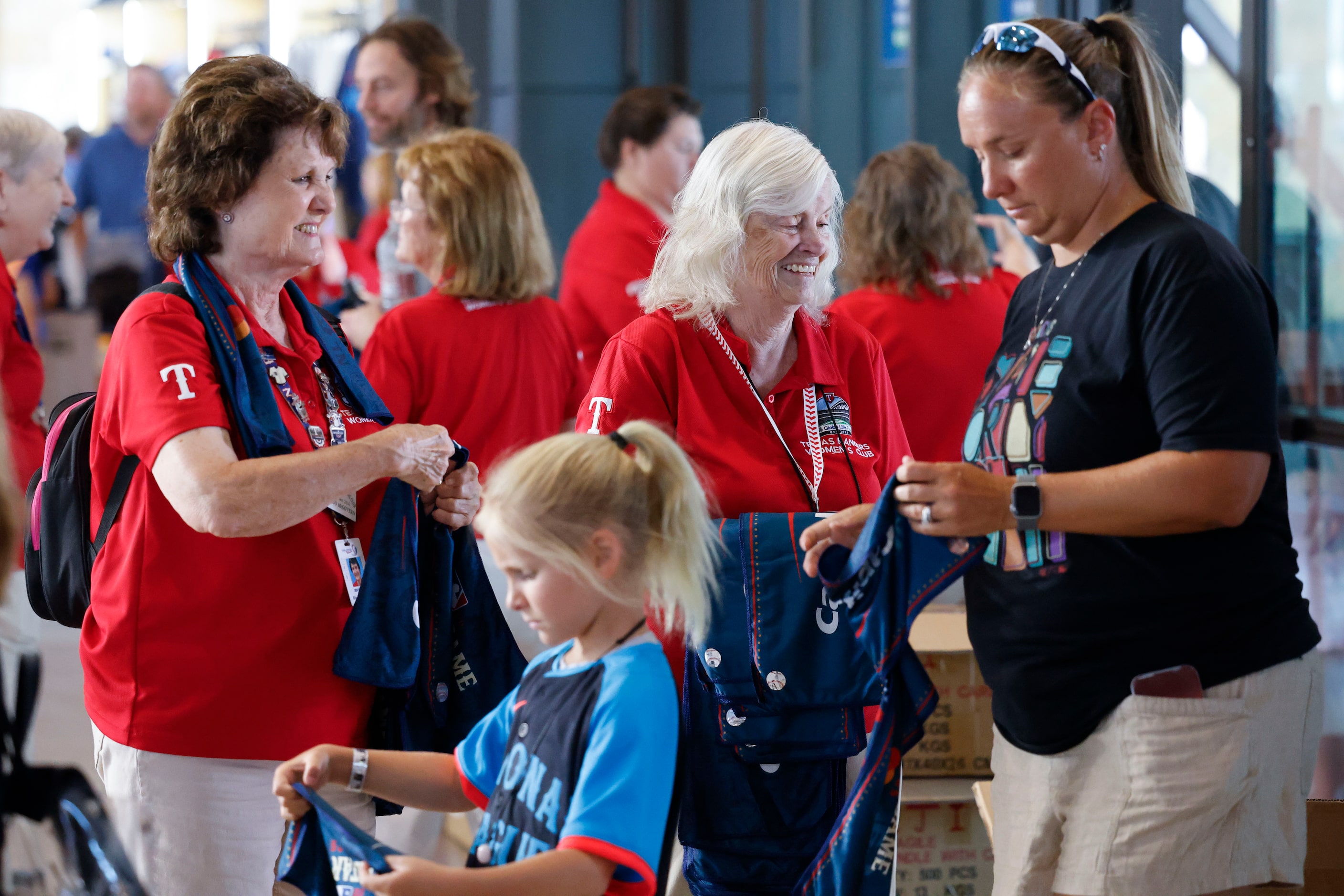 Texas Rangers Women’s Club members hand out towels ahead of MLB All-Star baseball game, on...