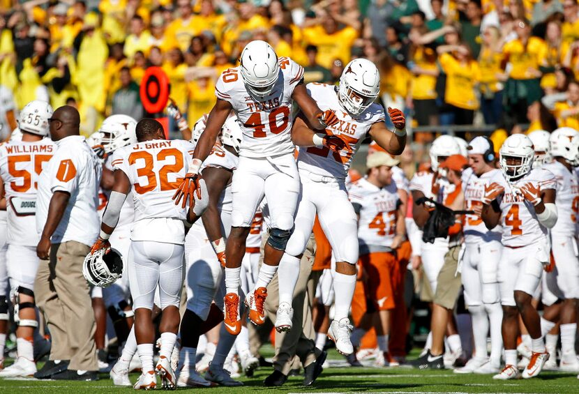 Texas defensive end Naashon Hughes (40) and cornerback Antwuan Davis (25) celebrate in the...