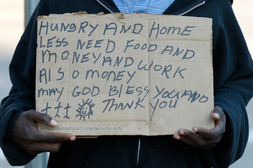 Larry Harris, 51, and homeless, panhandles at the intersection I-35E and Market Center in...