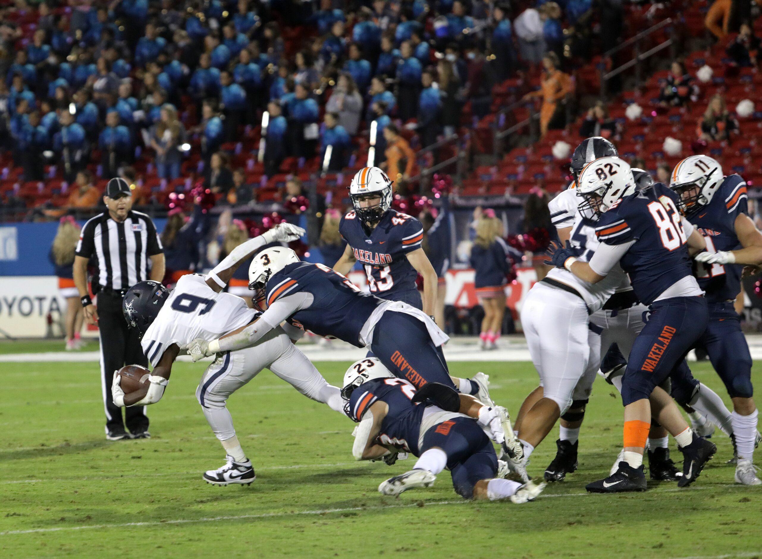 Lone Star player #9, Fogo Sokoya, is tackled by Wakeland player #3, Michael Flanagan, during...