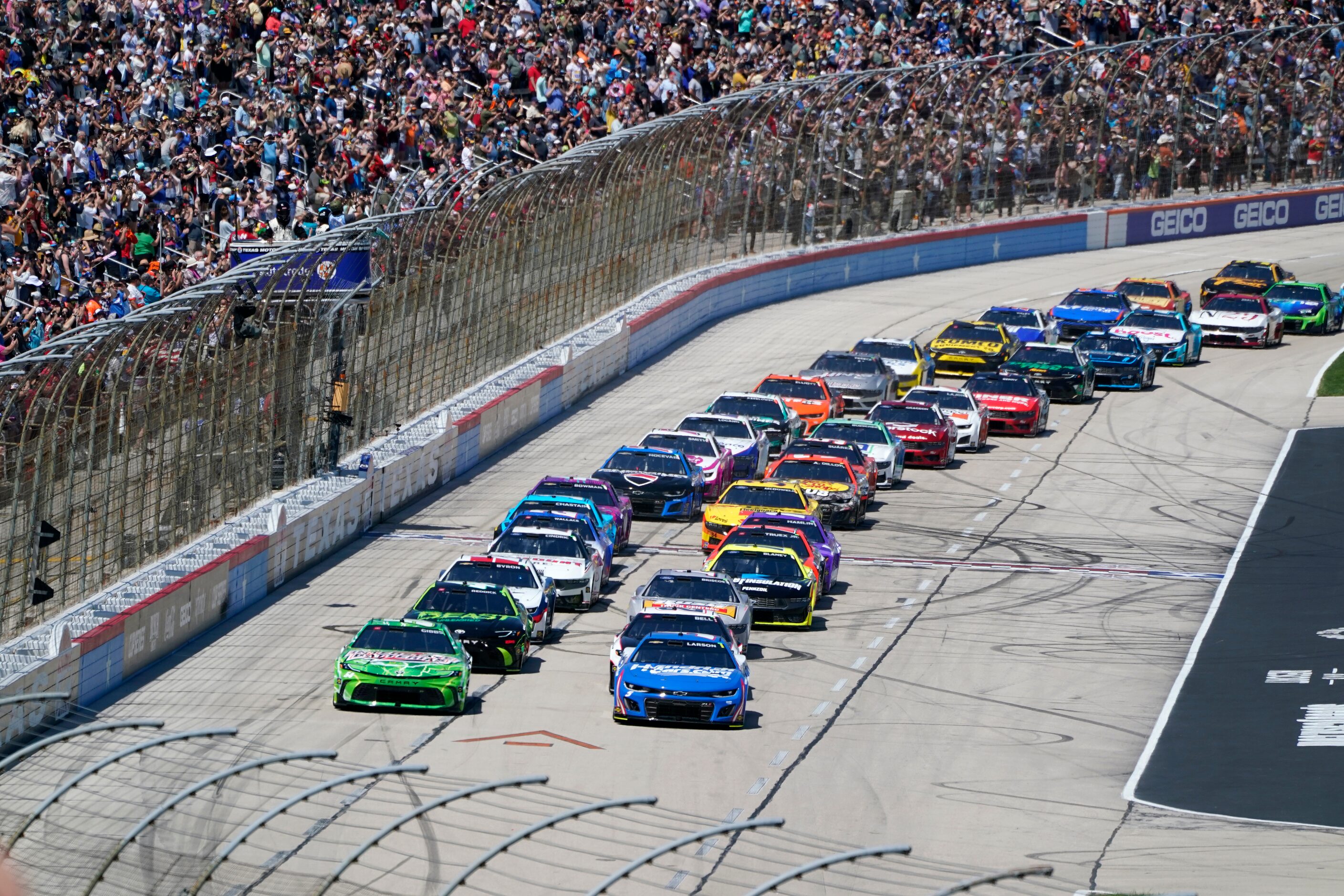 Ty Gibbs, left front, and Kyle Larson, right front, lead the field into Turn 1 after taking...