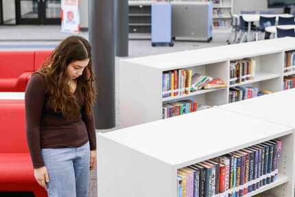 Thomas Jefferson High School student Jazmine Cabriales, pauses while rearranging the books...