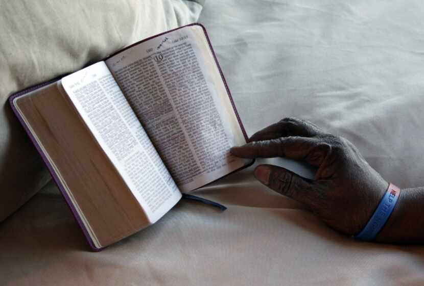 Carol 'Mama' Hawkins, 58, marks her favorite chapter in her Bible after placing it on her...
