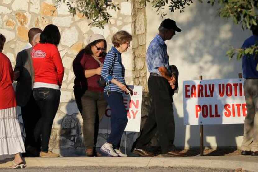 
Voters stand in line at an early voting polling site recently in San Antonio. The U.S....