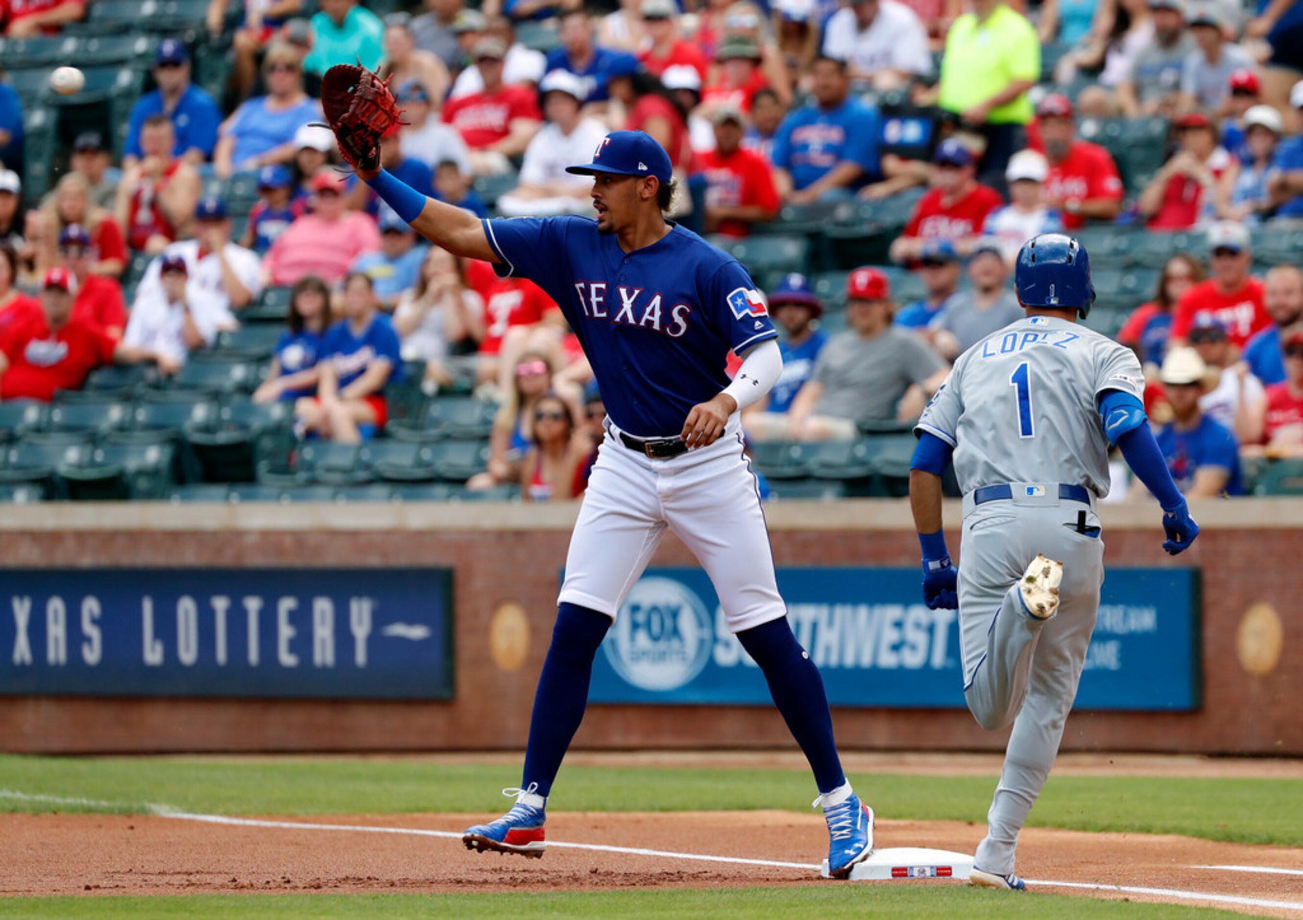 Texas Rangers' Ronald Guzman reaches up for the throw to first for the out against Kansas...