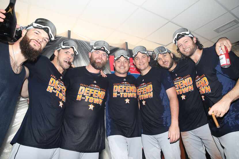Houston Astros players celebrate in the clubhouse after the team clinched the American...