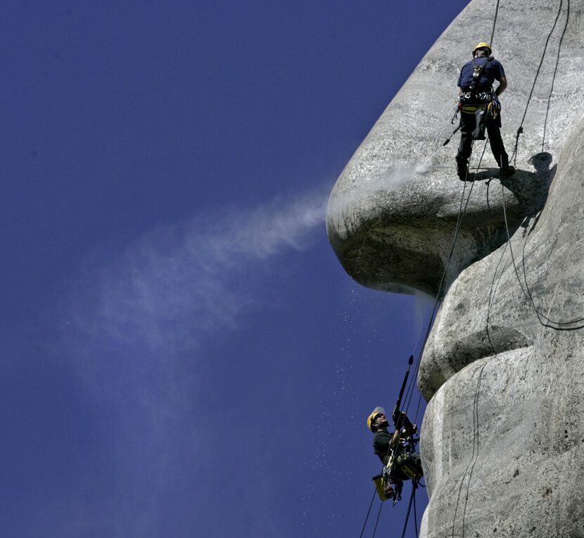 Winfried Hagenau, of Germany, bottom, and National Park Service employee Darin Oestman take...