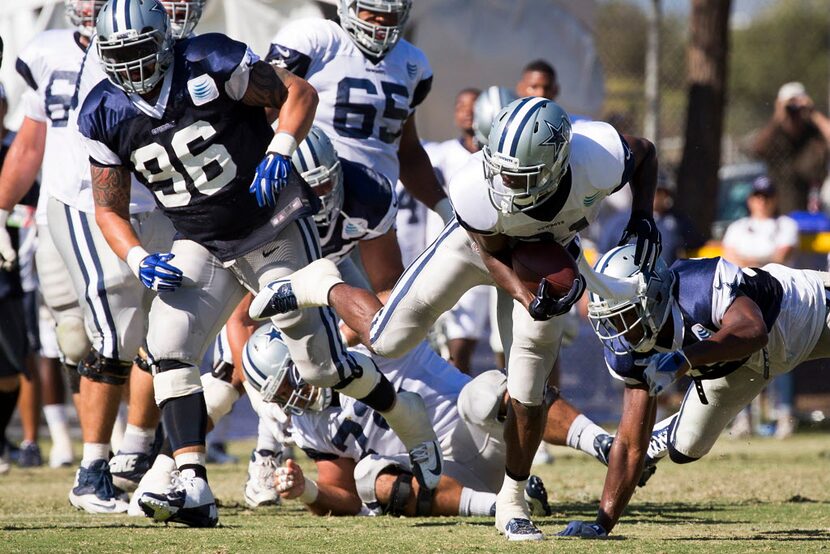 Dallas Cowboys running back Joseph Randle (21) breaks through the line during afternoon...