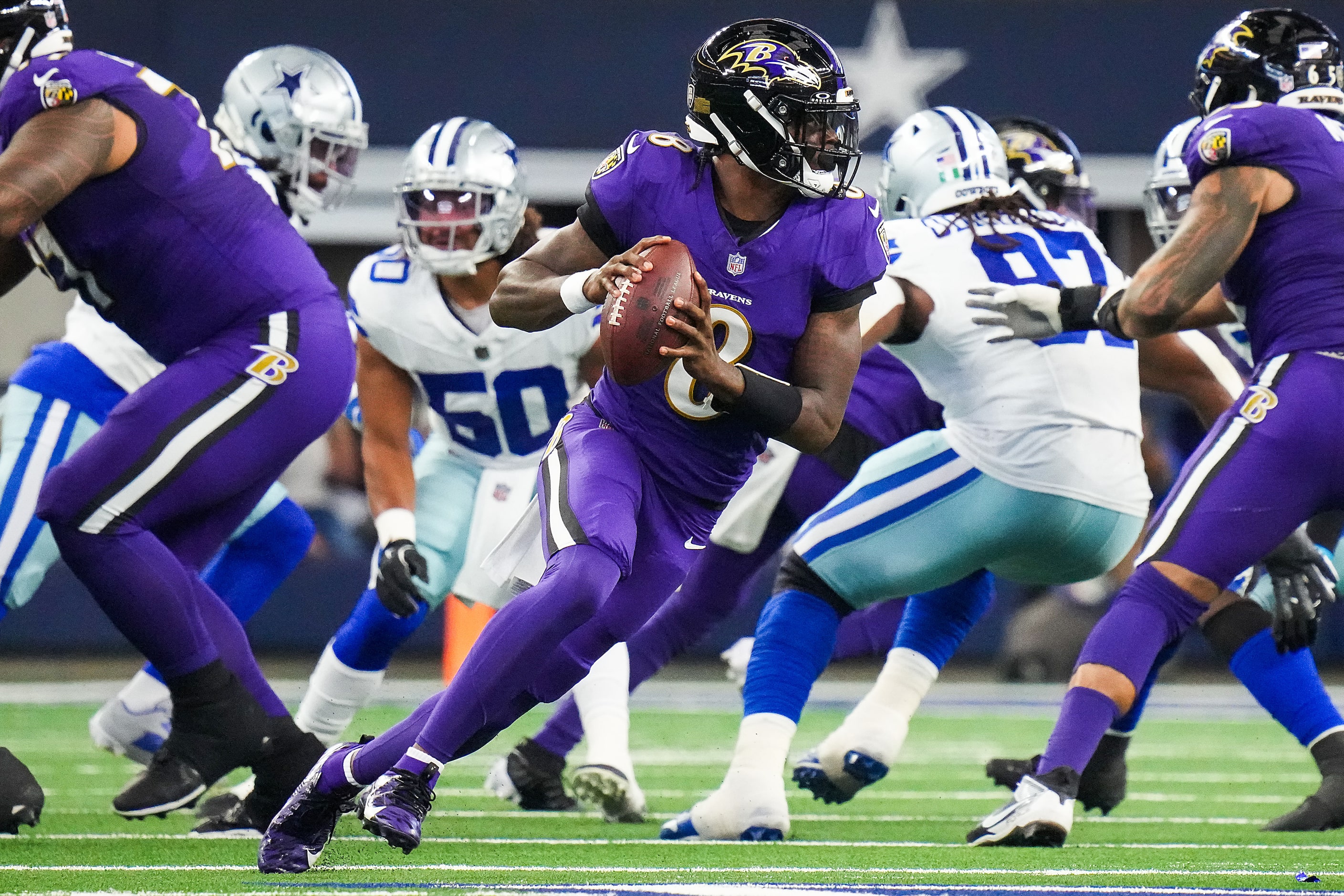 Baltimore Ravens quarterback Lamar Jackson (8) scrambles away from the Dallas Cowboys...