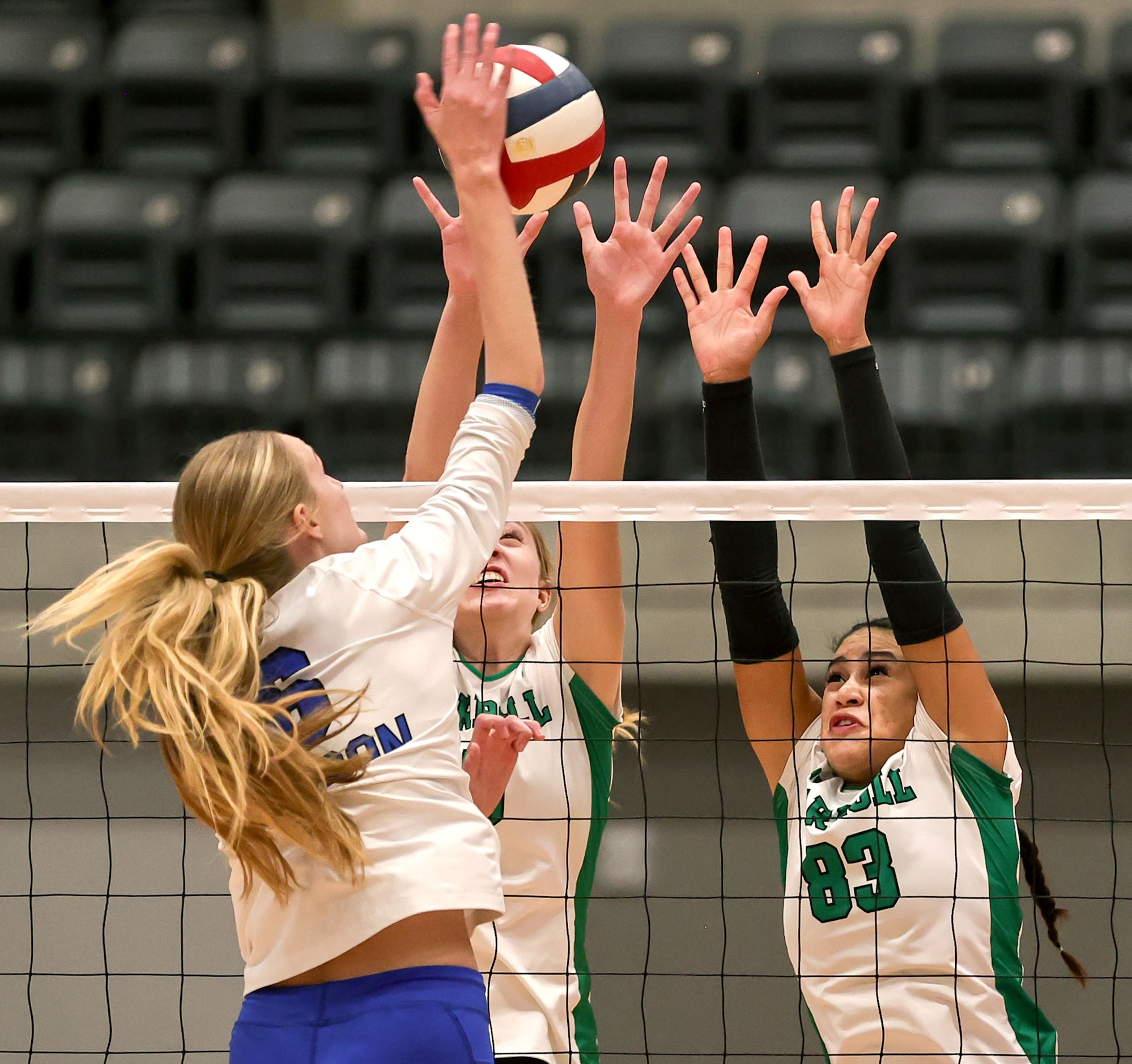 Hebron's Mary Beth Morse (L) goes for a kill against Southlake Carroll's Abby Huddleston and...