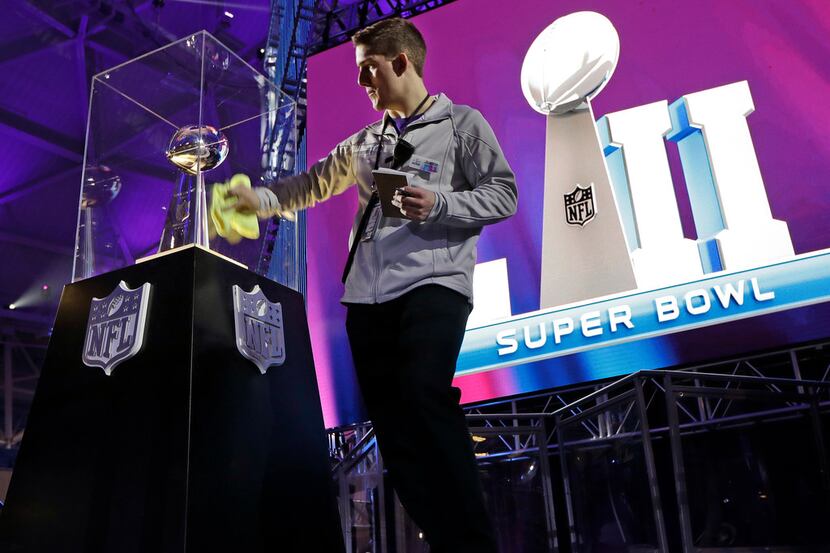 Justin Tacheny polishes the case around the Vince Lombardi Trophy at the NFL Experience...