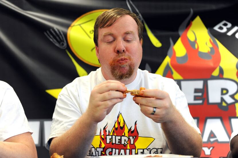 Sean eats wings by Wing Town at the Taste of Irving Fiery Heat Challenge in Irving, TX on...
