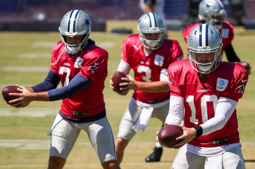 El mariscal de campo de los Cowboys Cooper Rush (10) realiza un ejercicio con Ben DiNucci...