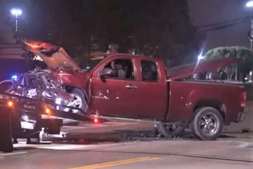 A tow truck hoists the damaged pickup that was involved in the deadly collision Friday,...