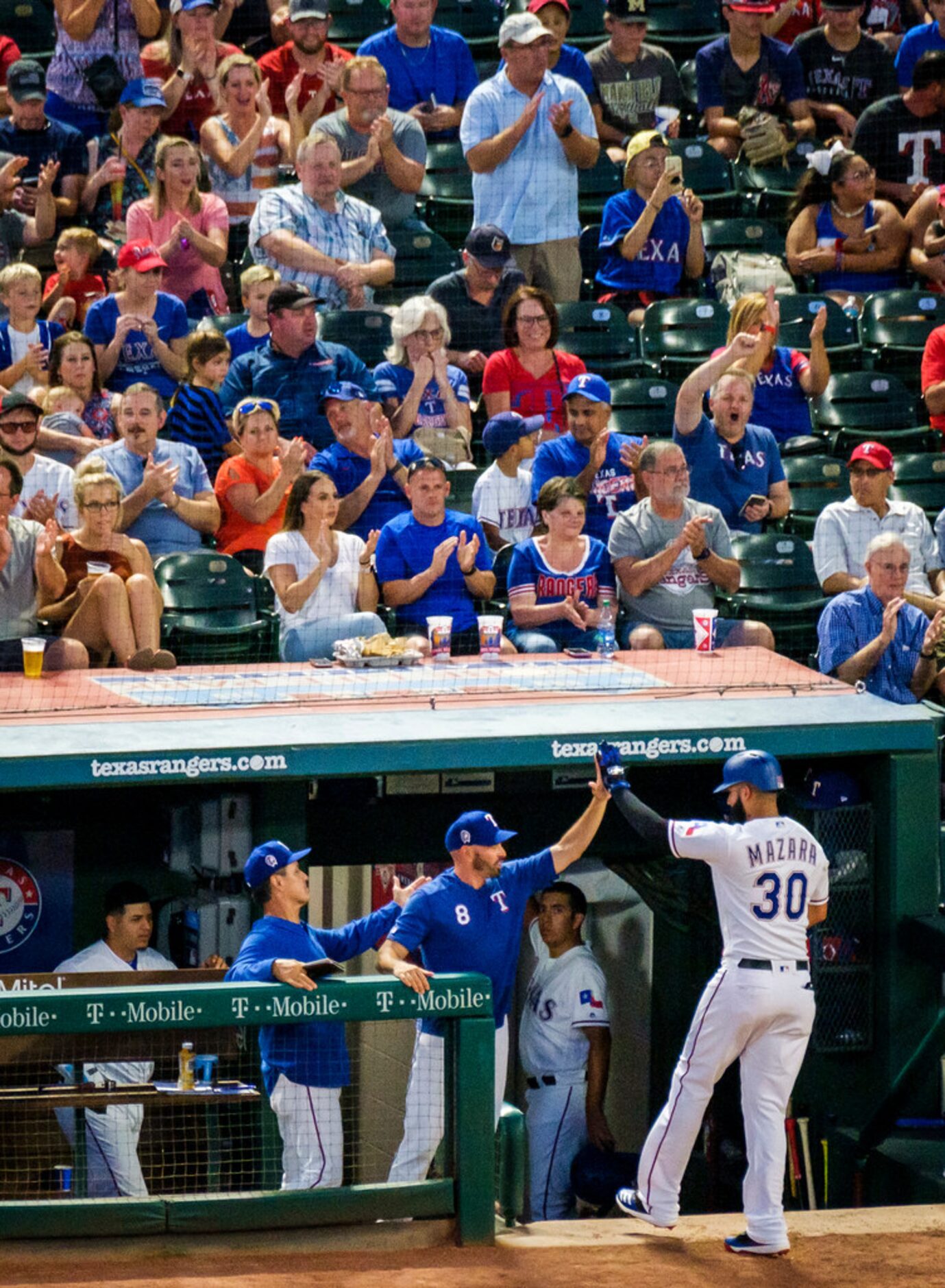 Texas Rangers right fielder Nomar Mazara (30) gets a hand from manager Chris Woodward after...