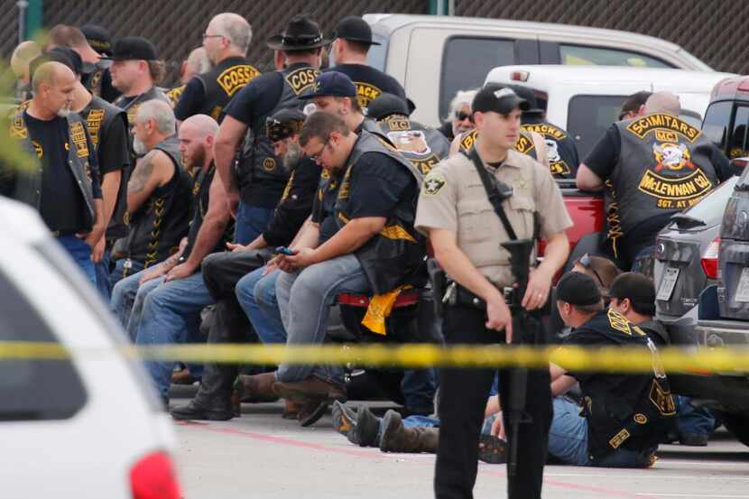 
A McLennan County deputy stands guard near a group of bikers in May in the parking lot of a...