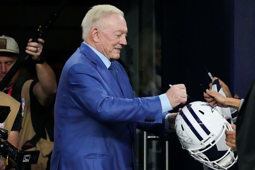 Dallas Cowboys owner and general manager Jerry Jones signs autographs before an NFL football...