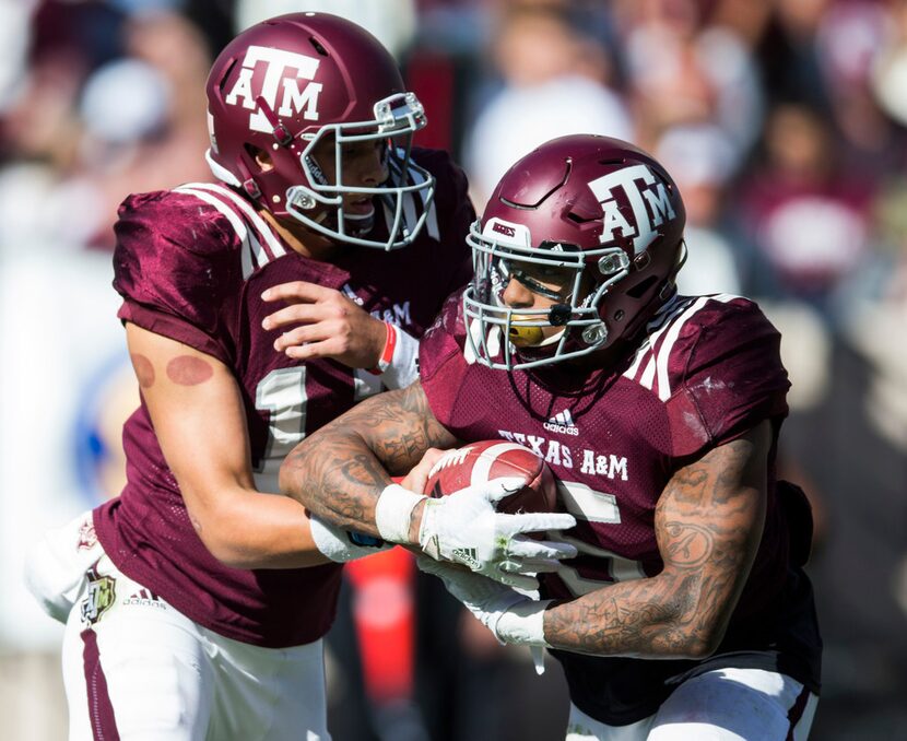 Texas A&M Aggies quarterback Nick Starkel (17) hands off the ball to running back Trayveon...