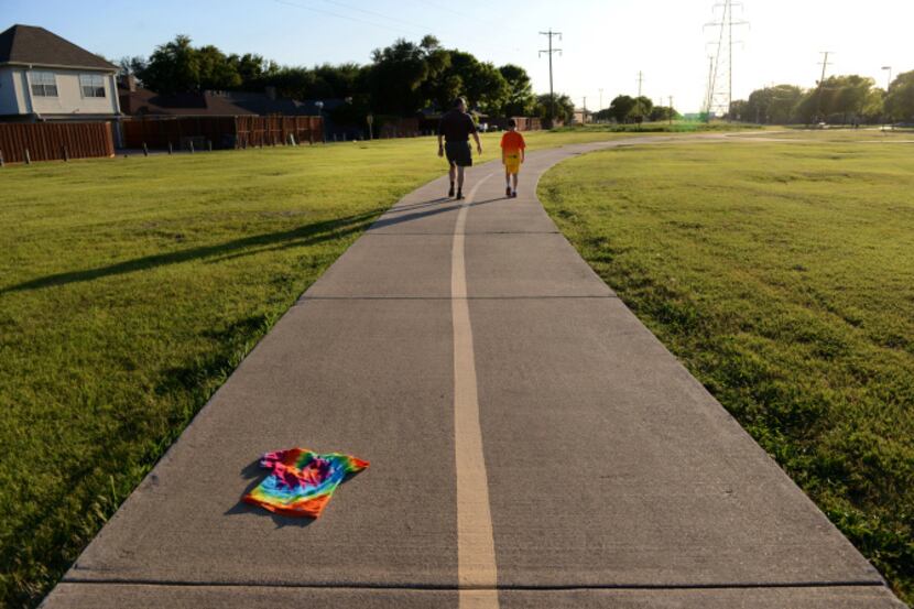 Barry Rosen walks with his son Asher, 9, along the trails surrounding their Prestonwood...