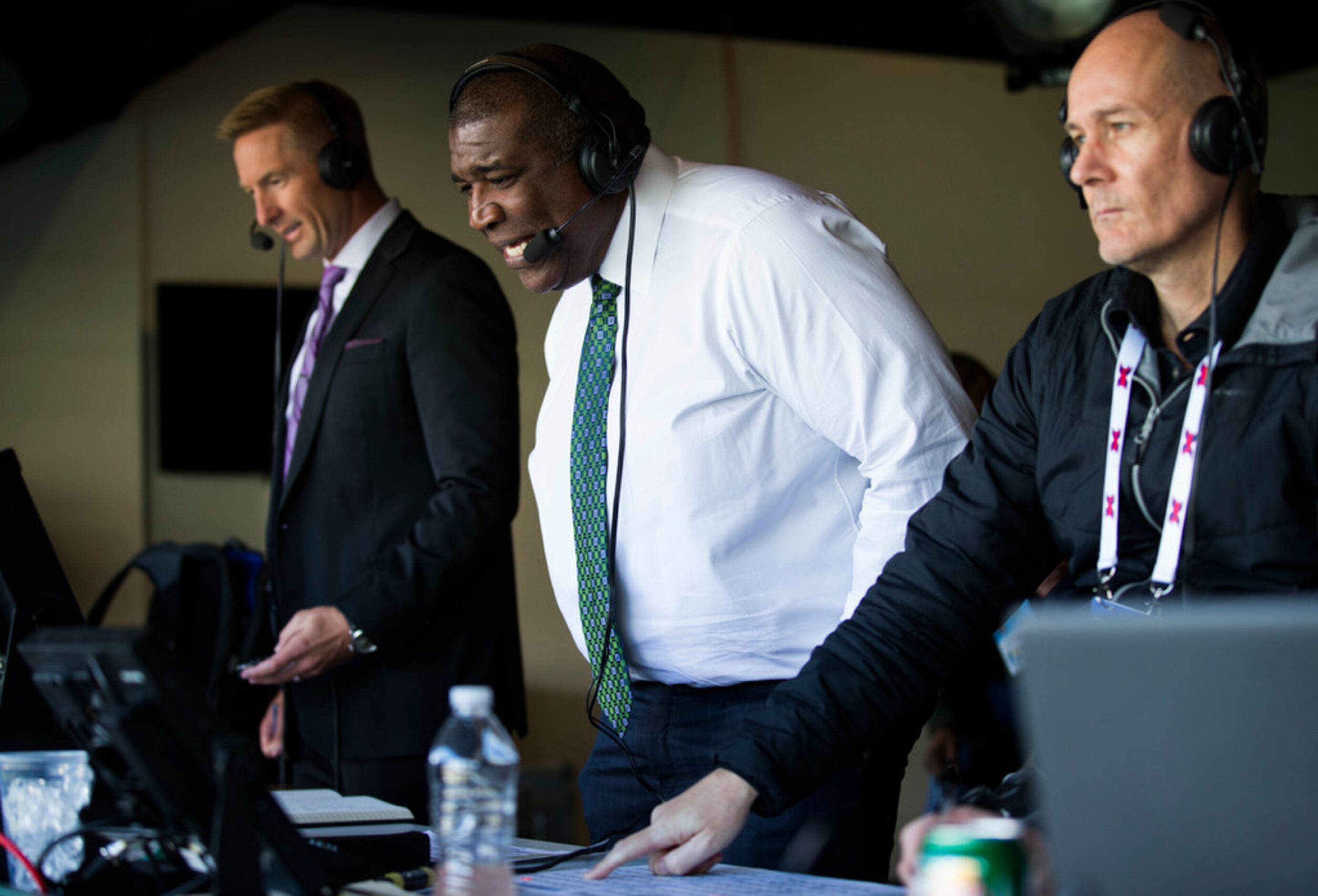 FOX Sports broadcasters Joel Klatt (left) and Curt Menefee (center) call an XFL game between...